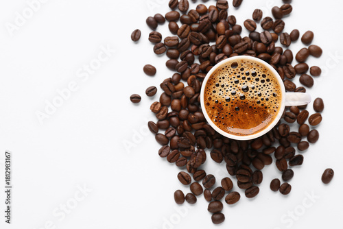 Coffee beans and cup of coffee on white background