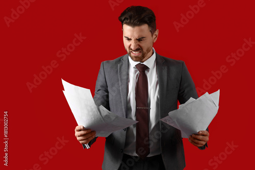 Angry businessman with pape...