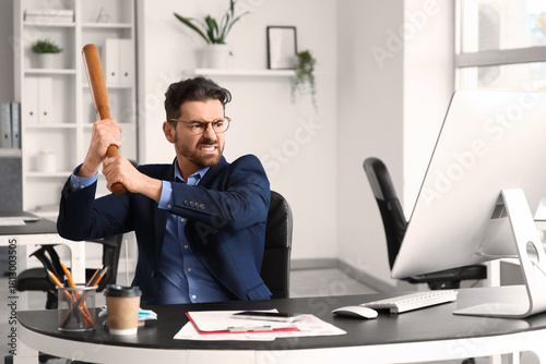 Angry businessman with bat ...