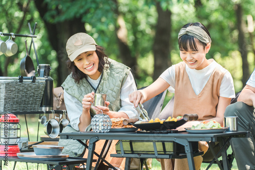 Friendly families and parents and children enjoying a barbecue at a park or campsite

