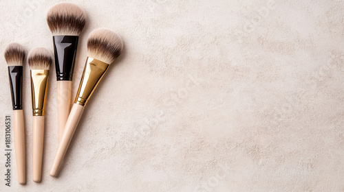 Soft makeup brush set with gold ferrule and neutral handles on textured background