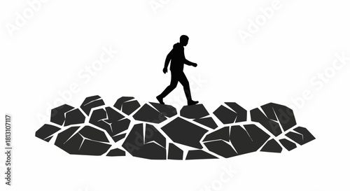 Silhouette of a man walking on rocks, navigating a challenging path.