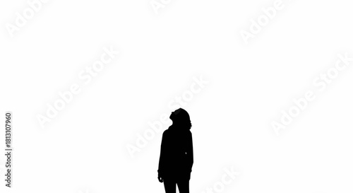 Silhouette of a person standing alone, contemplating and looking into the distance.