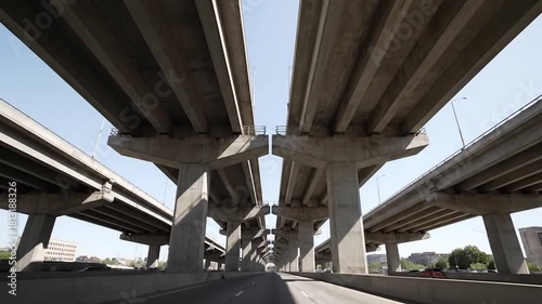 Urban highway overpass perspective driving under massive concrete elevated roads and flyovers