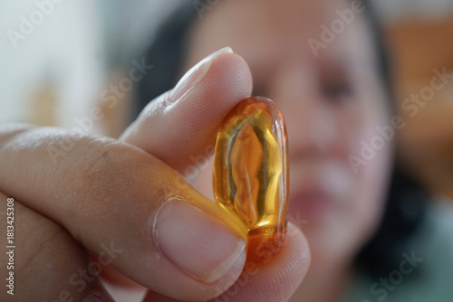 A person holds a shiny amber piece, showcasing its translucent qualities and natural beauty against a blurred background.