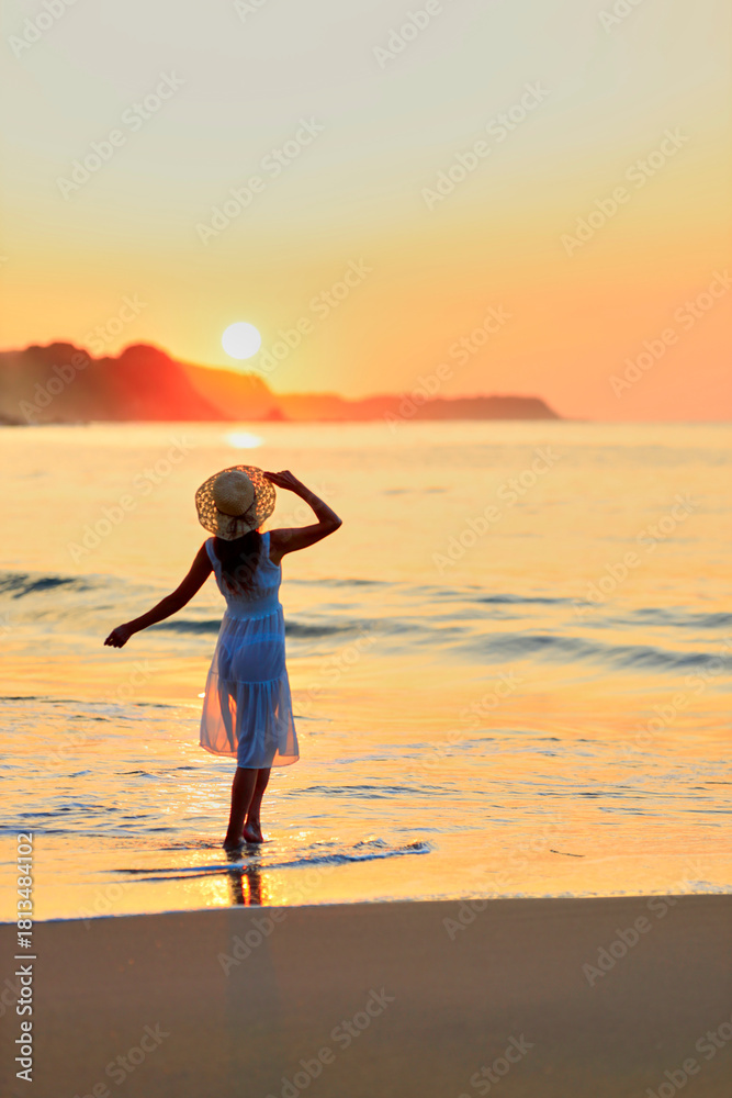 Fototapeta premium 夕焼けの海を眺める彼女