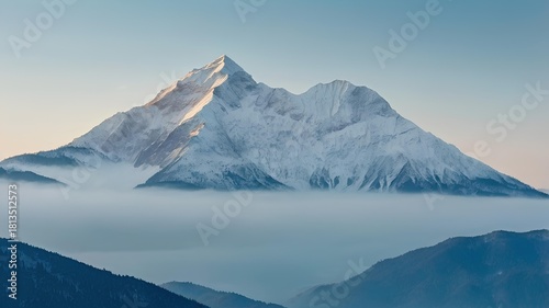 Snow Covered Mountain Peak Above the Clouds at Sunrise