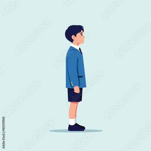 Young boy in school uniform standing in profile looking forward with a serious expression.