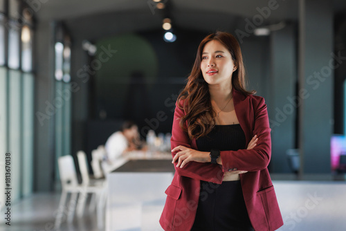 Confident young asian entrepreneur crossing arms in office