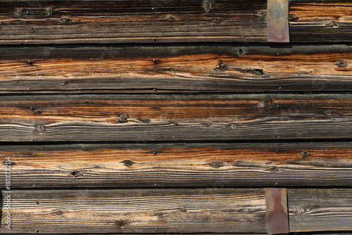 経年変化した古い横張りの板壁とさびた金属バンドのテクスチャー
