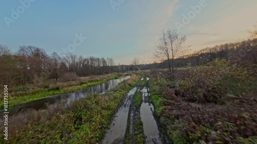 A low and fast drone flight over a river and meadow.