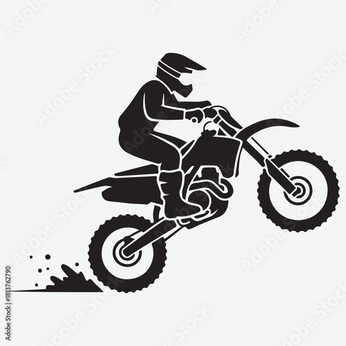 Silhouette of a Motocross Rider Performing a Wheelie on a Dirt Bike