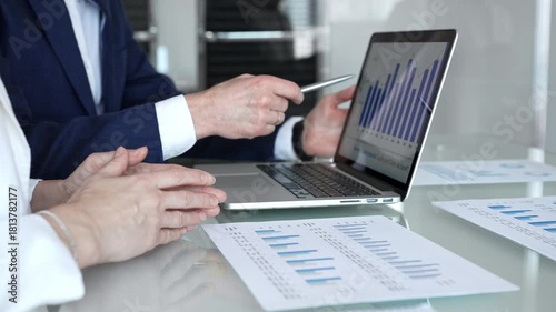 Businesspeople hands gesturing and reviewing contracts on a glass table during an important negotiation, concluding a deal in a professional corporate environment