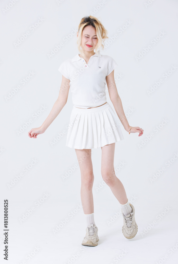 Naklejka premium Asian confident attractive beautiful woman blonde hair tied stand wear white shirt top mini skirt sport on background studio portrait fashion street outfit trendy style pose look at camera full length
