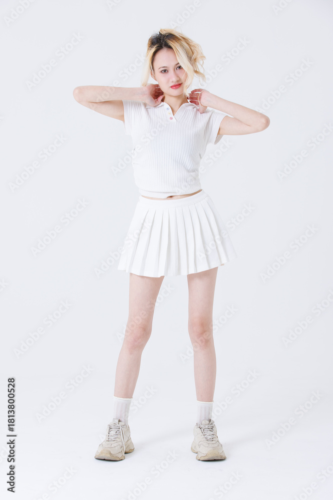 Fototapeta premium Asian confident attractive beautiful woman blonde hair tied stand wear white shirt top mini skirt sport on background studio portrait fashion street outfit trendy style pose look at camera full length