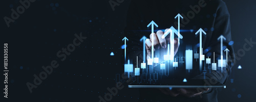 Business growth and technology concept with glowing financial chart bars and arrows rising above tablet in creative digital background.