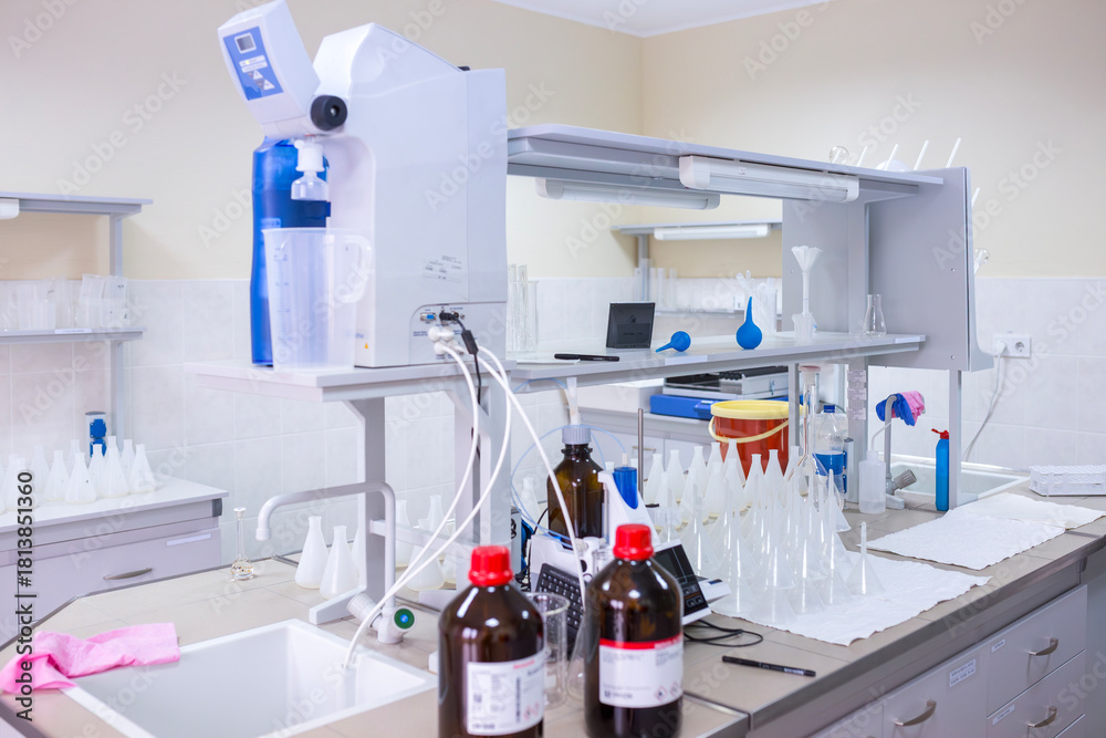 Φωτογραφία Modern laboratory table with glass flasks bottles of reagents a water purificati