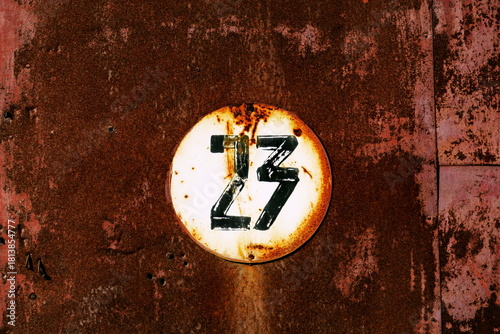 Vingt trois. Numéro 23. Plaque de numéro de rue sur fond rouillé.