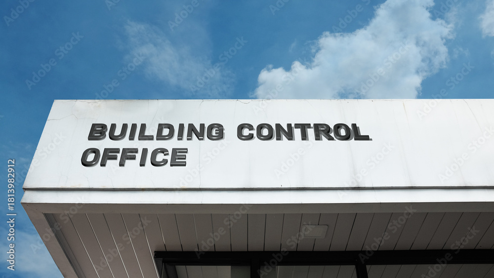 Obraz premium Building Control Office word sign on exterior facade under clear blue sky, representing construction regulation, inspection, safety, and compliance