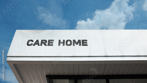 Care Home word sign displayed on a building under a clear blue sky, representing elderly care, assisted living, healthcare services, and residential facilities