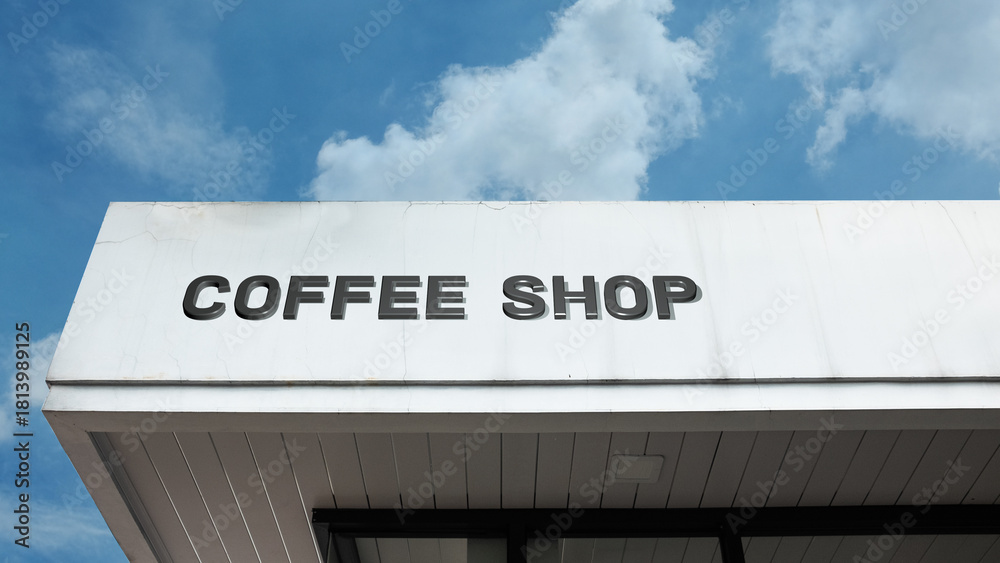 Obraz premium Coffee Shop word sign displayed on a building under a clear blue sky, representing café culture, beverages, socializing, leisure, and hospitality facilities