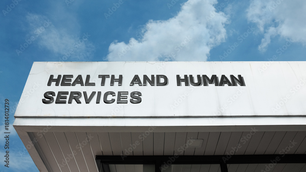Obraz premium Health and Human Services sign displayed on a building against a clear blue sky, symbolizing public welfare, social support, medical aid, and civic aid