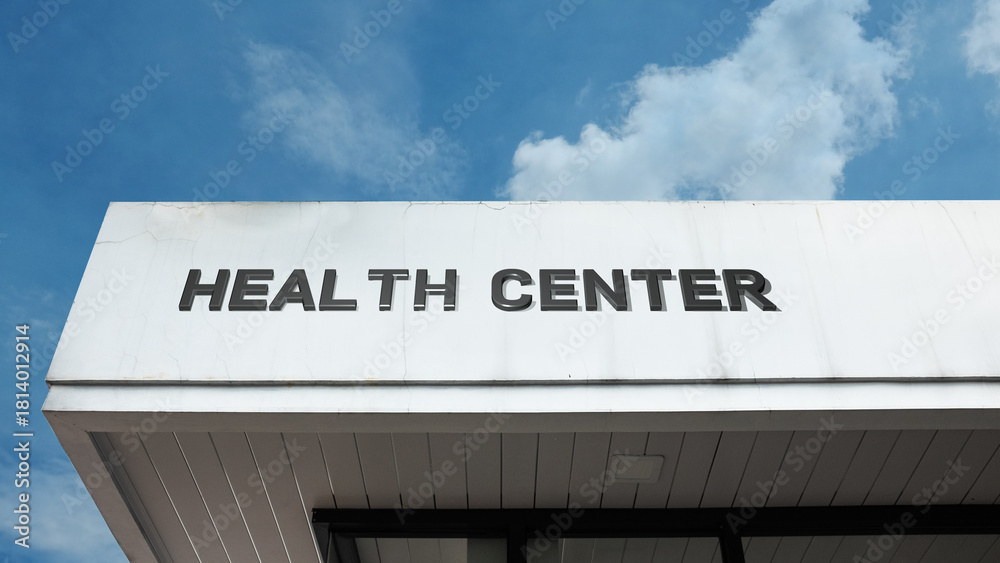 Obraz premium Health Center sign displayed on a building against a clear blue sky, symbolizing medical facility, community clinic, patient care, wellness, and professional services