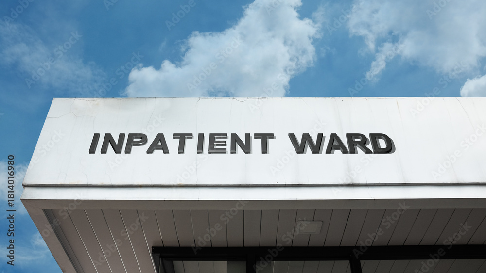 Obraz premium Inpatient Ward sign on a building against a clear blue sky, symbolizing medical treatment, hospital care, patient recovery, overnight stay, and health