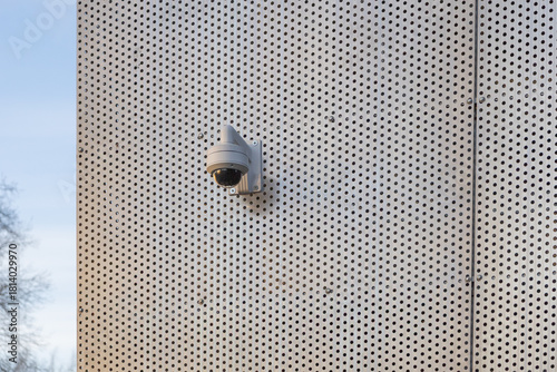 A surveillance security camera installed on the exterior wall of a building, used for monitoring and safety in an urban environment