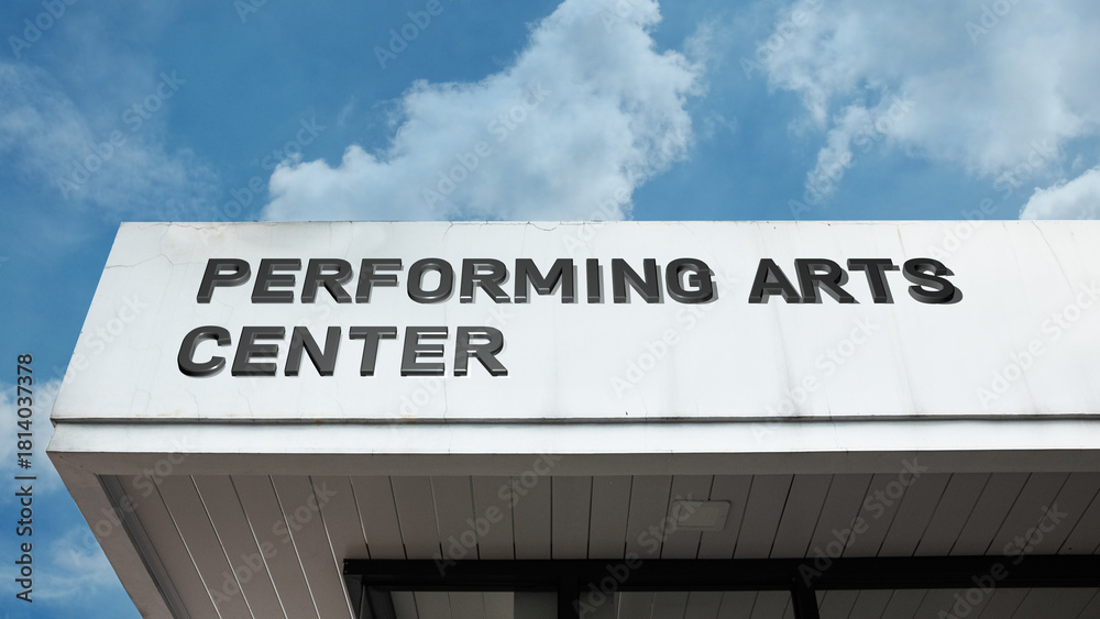 Obraz premium Performing Arts Center word signage on a grand cultural building under a blue sky, symbolizing theater, music, culture, and entertainment venue