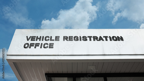 Vehicle Registration Office word signage on a government building under a blue sky, symbolizing regulation, licensing, transportation law, bureaucracy, and official administration