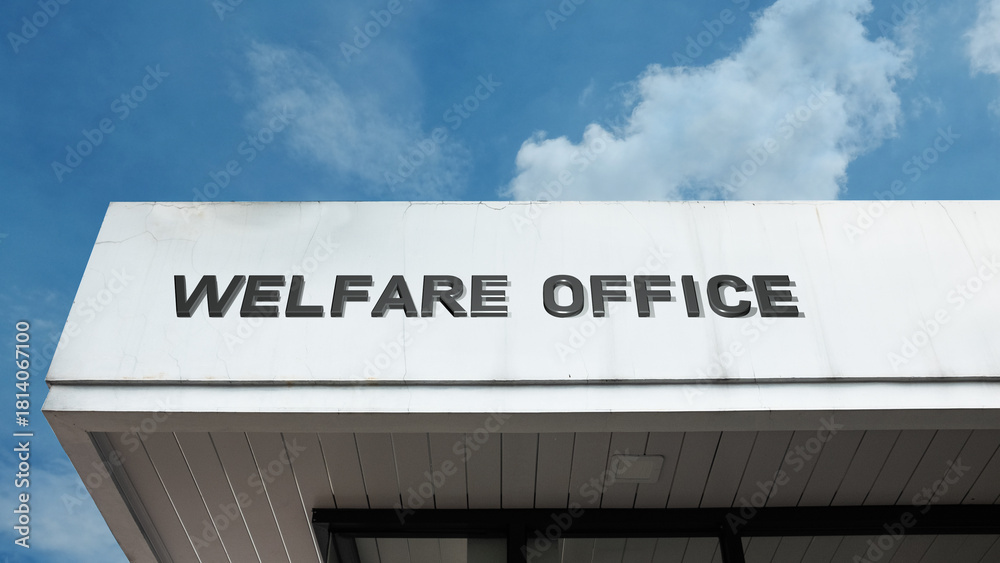 Obraz premium Welfare Office word signage on a government building under a blue sky, symbolizing public aid, social security, community support, assistance, and relief programs