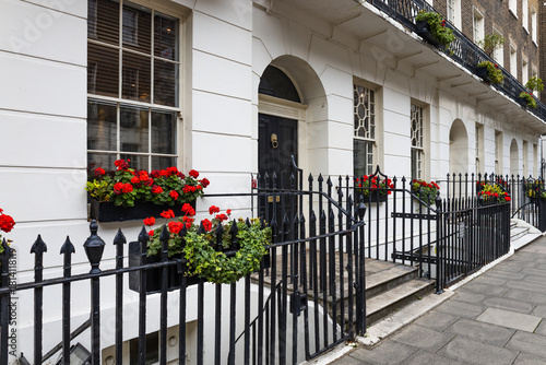 Elegant Georgian terrace in London with flowered windows and wrought iron railings