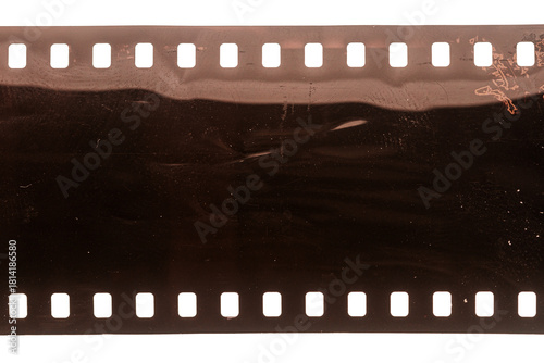Dusty and grungy 35mm film texture or surface. Perforated scratched camera film isolated on white background.