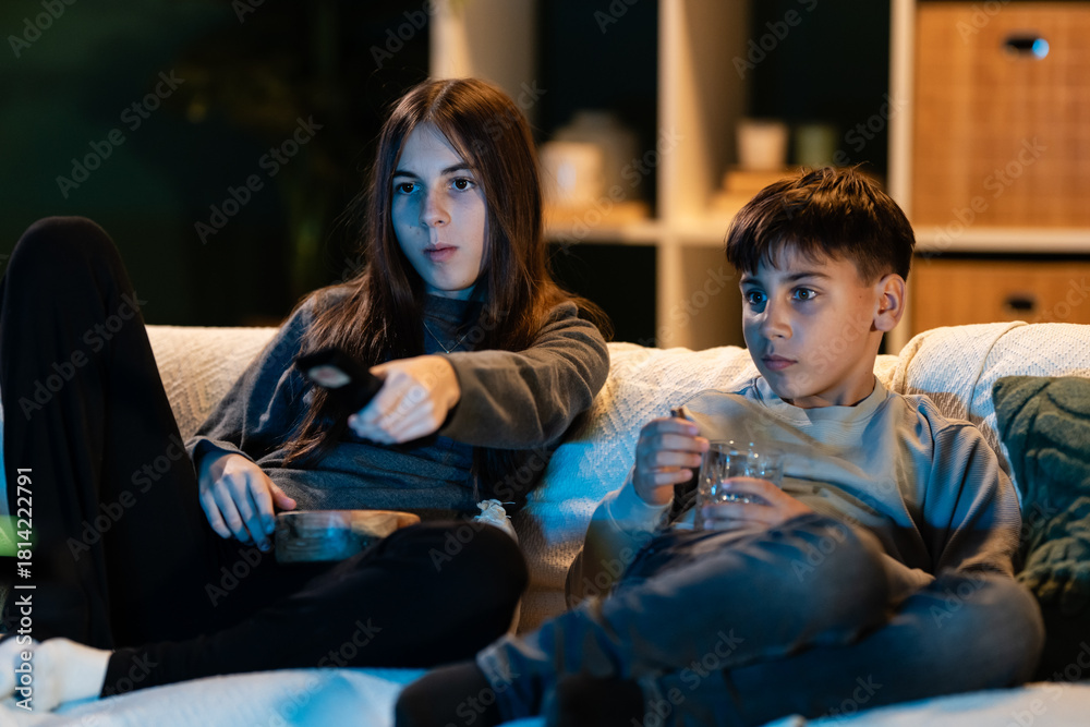 Fototapeta premium Siblings enjoying movie night watching television