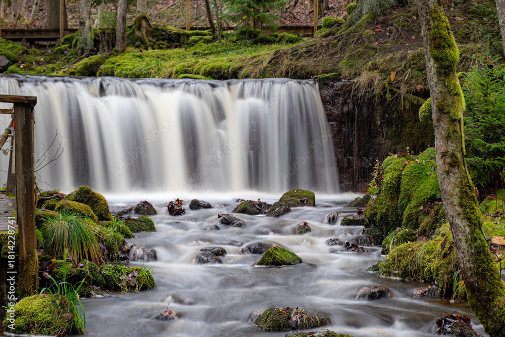 Fototapeta premium A long exposure view of a waterfall in a small rapid river, autumn landscape, November in nature, Ieriku mill, Melderupe, Latvia