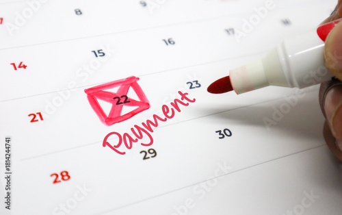 Foto Close up of a hand highlighting an important payment due date on a calendar, emp