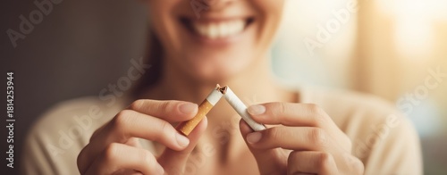The cigarette being broken by a smiling woman as she quits smoking today
