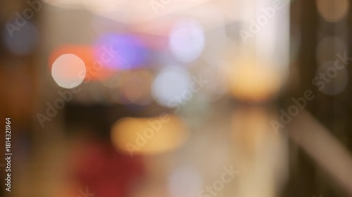Blurred crowd of people shopping at a mall before Christmas on Black Friday with festive bokeh lights and warm holiday atmosphere.