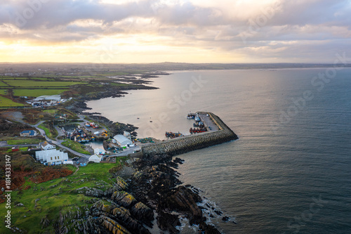Aerial view of Port Oriel in Clogherhead with fishing boats and hazy evening light along the calm coastline