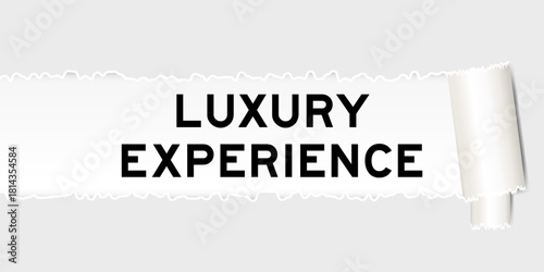 Ripped gray paper background that have word luxury experience under torn part