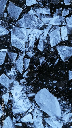 Super slow motion of falling piece of ice on black background. Filmed on high speed cinema camera, 1000 fps. Vertical aspect ratio.
