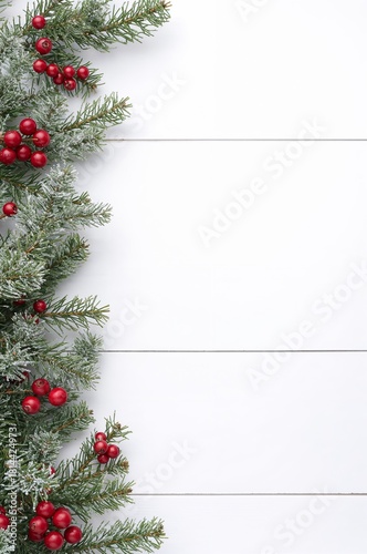 Festive Holiday Decorations With Pine Branches and Red Berries on a White Woo...
