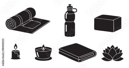 Collection of black silhouette icons representing yoga and meditation essentials, including a mat, block, water bottle, candles, and a lotus flower