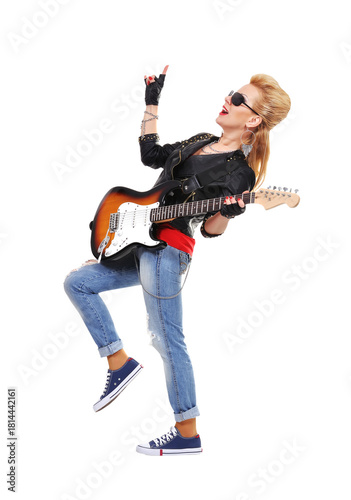 A rocker girl in ripped jeans poses for the camera with an electric guitar
