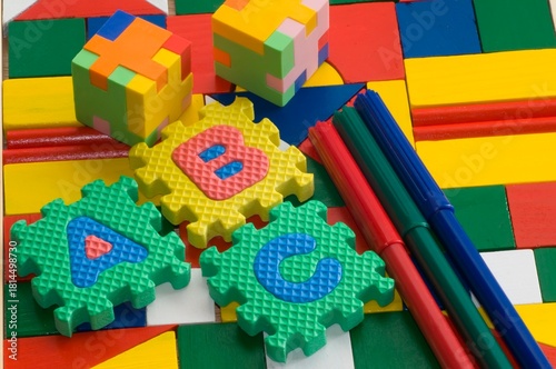 Colorful blocks and plastic alphabets  on colorful wooden background