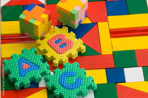 Colorful blocks and plastic alphabets  on colorful wooden background