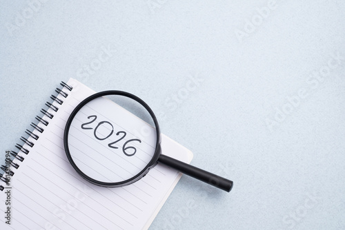 Happy New Year 2026 and a notepad on a colored background. Layout for writing annual business plans, schedules, as well as New Year's resolutions and goals.