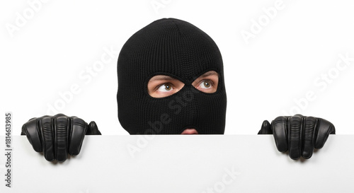 A masked burglar peeks over a white empty banner. The individual wears a black ski mask and leather gloves, suggesting stealth and secrecy in a robbery context.