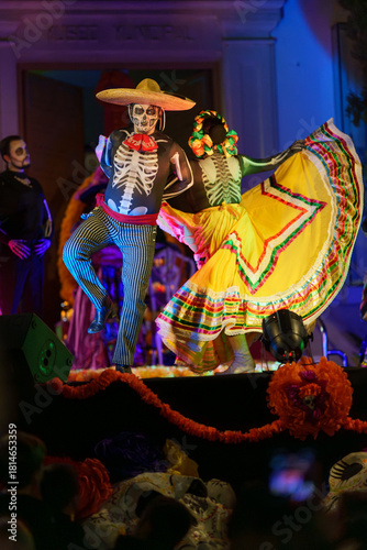 Day of the Dead Skeleton Couple Performing Mexican Folkloric Dance with Yellow Skirt on Stage